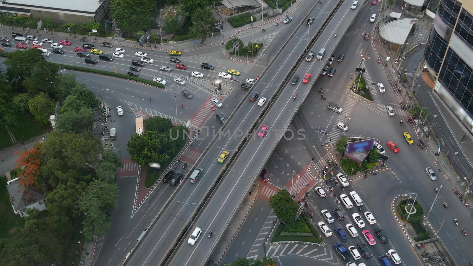 Traffic on crossroad on street. From above modern cars and motorcycles driving on intersection on street in center of Bangkok, Thailand.