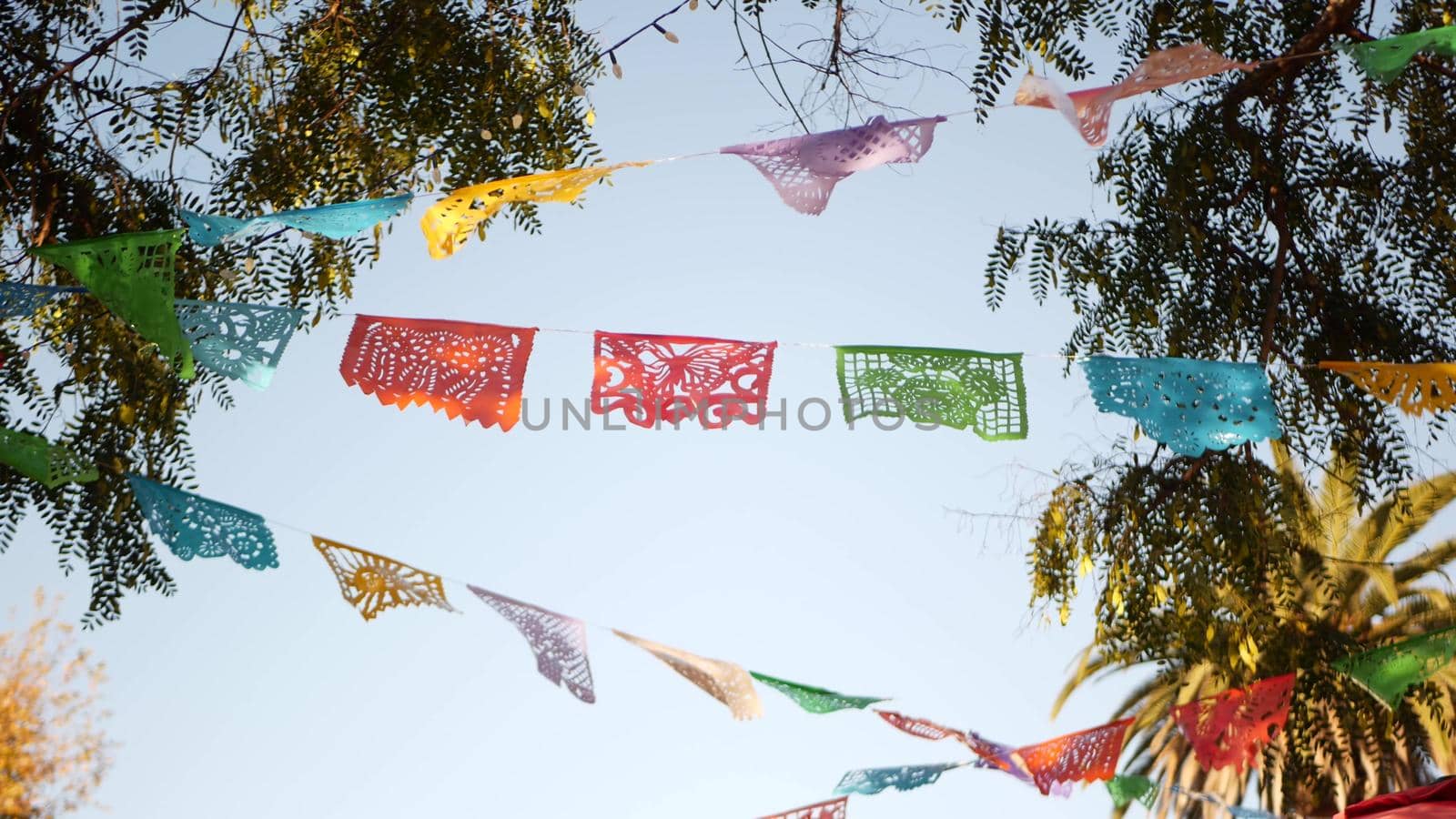 Colorful mexican perforated papel picado banner, festival colourful paper garland. Multi colored hispanic folk carved tissue flags, holiday or carnival. Authentic fiesta decoration in Latin America by DogoraSun