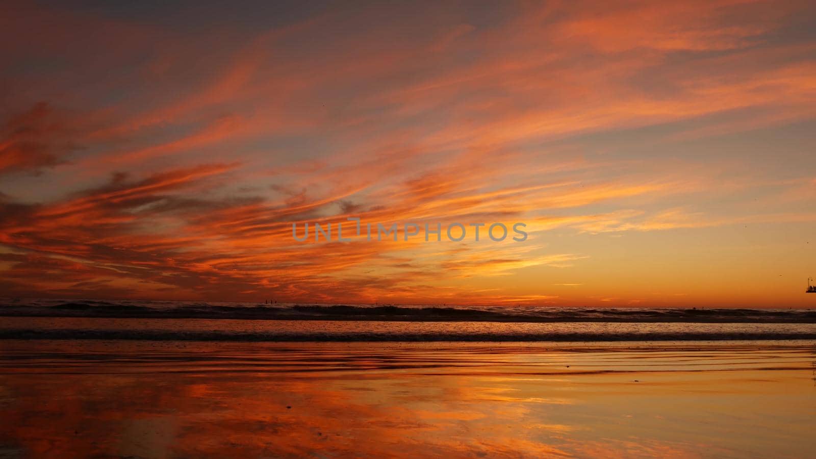 California summertime beach aesthetic, golden sunset. Vivid dramatic clouds over pacific ocean waves. Santa Monica popular resort, Los Angeles CA USA. Atmospheric moody purple evening sundown in LA.