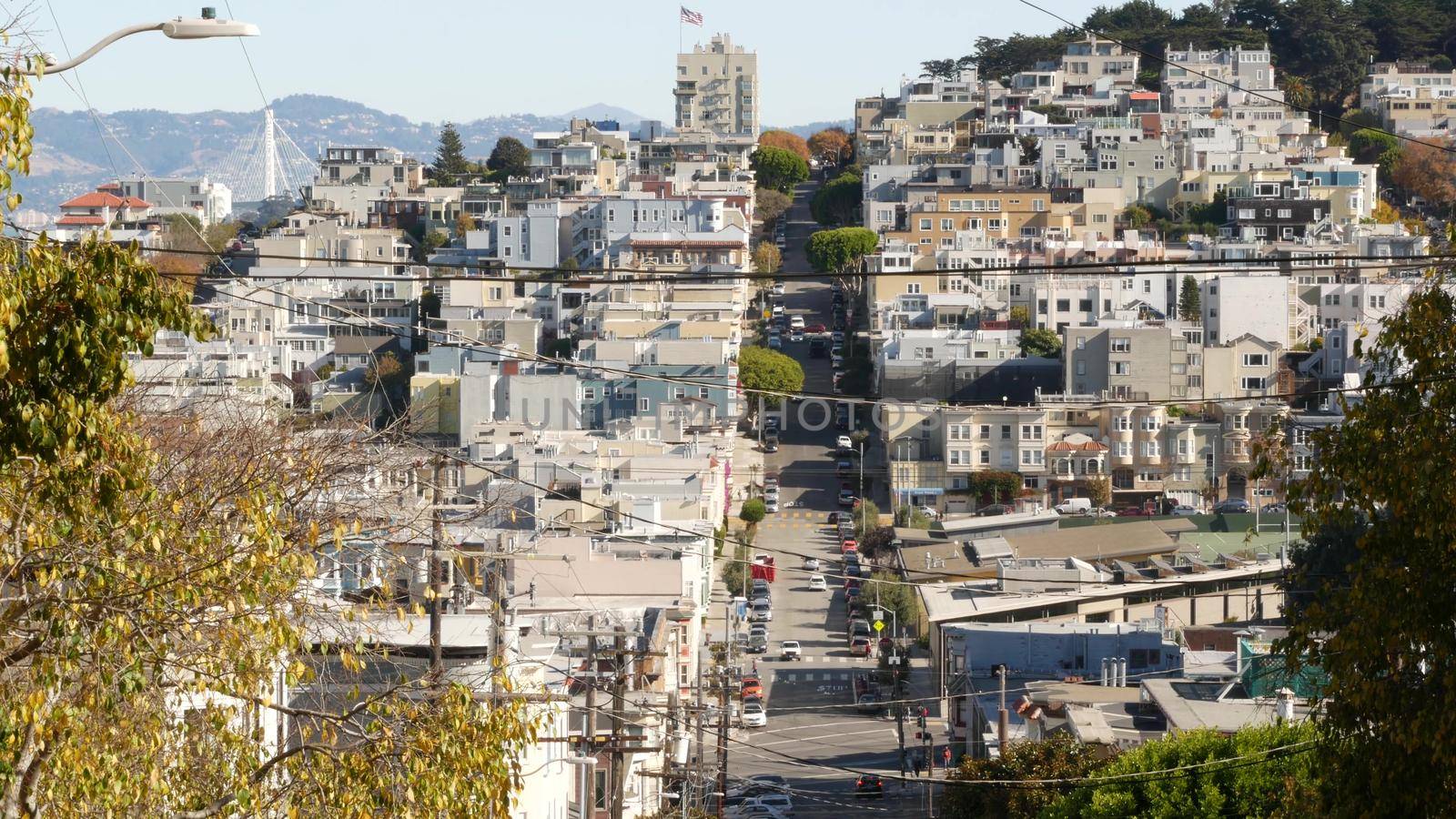 Iconic hilly street and crossroads in San Francisco, Northern California, USA. Steep downhill road and pedestrian walkway. Downtown real estate, victorian townhouses abd other residential buildings by DogoraSun