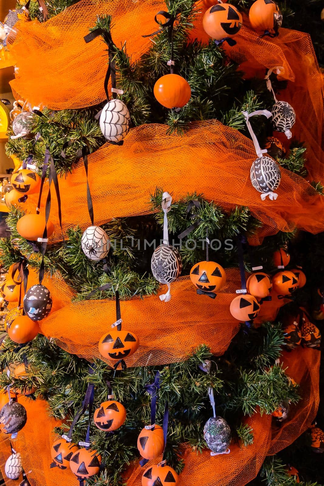 The green Christmas tree is beautifully decorated with toys. Halloween