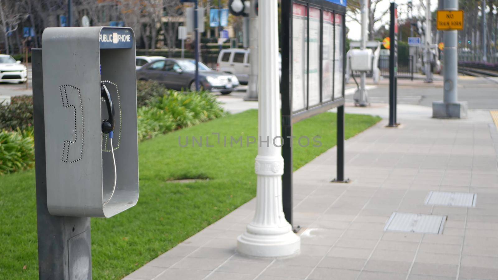 Retro coin-operated payphone station for emergency call on street, California USA. Public analog pay phone booth. Outdated technology for connection and telecommunication service. Cell handset on box.