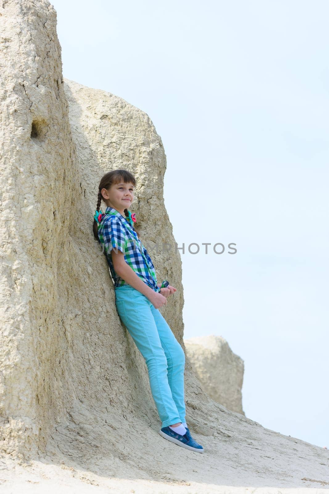 Ten year old girl pressed her back against a rock