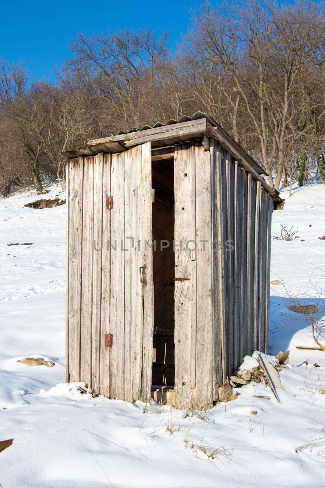 Old wooden outdoor toilet in winter weather