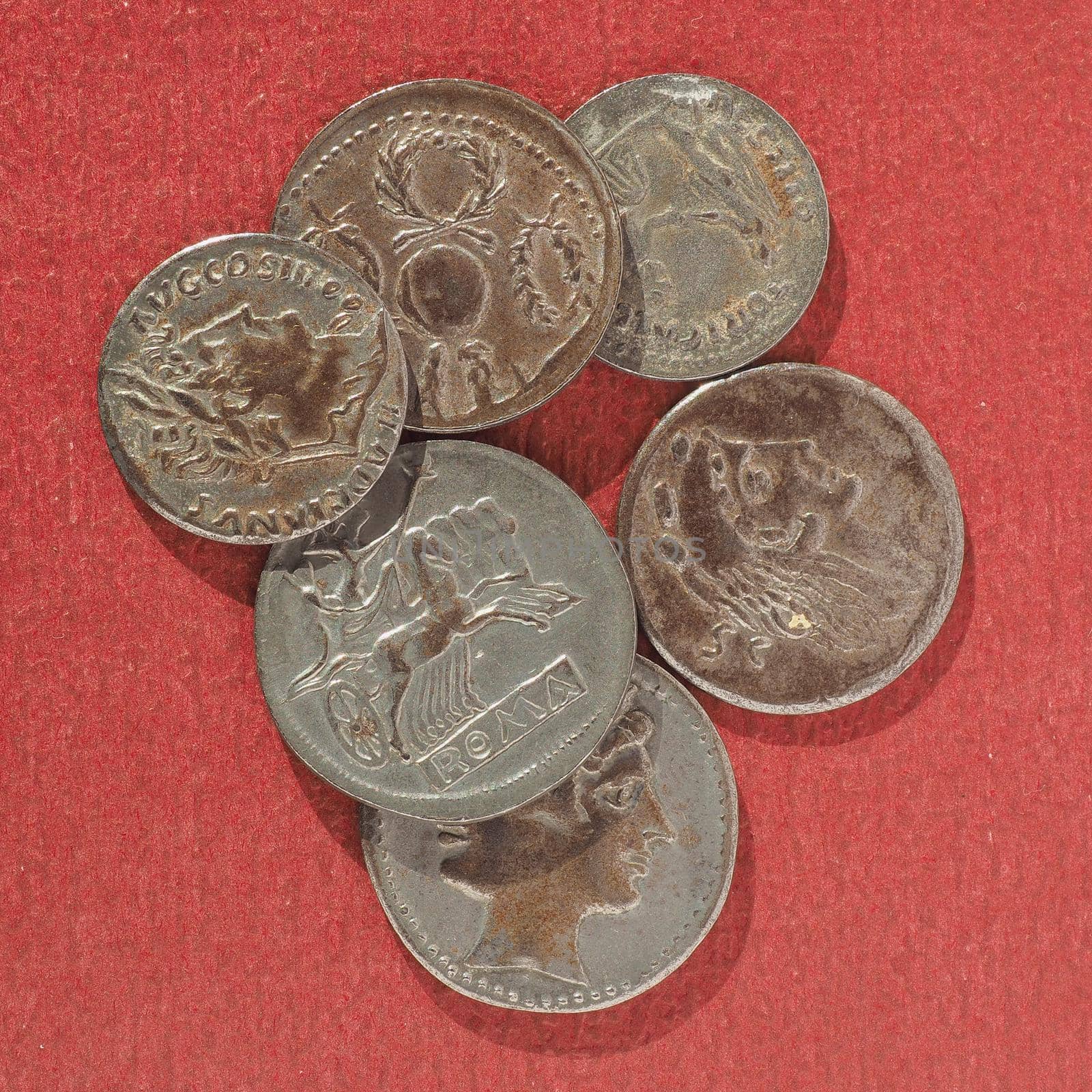 Ancient Roman coins over a red background
