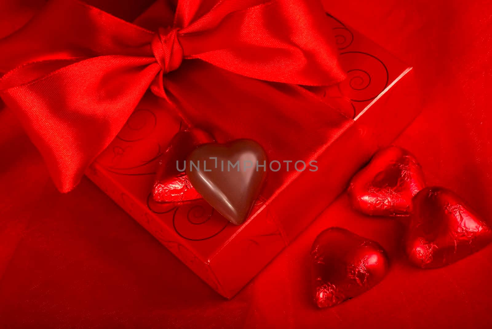 Gift and sweets heart on a red background