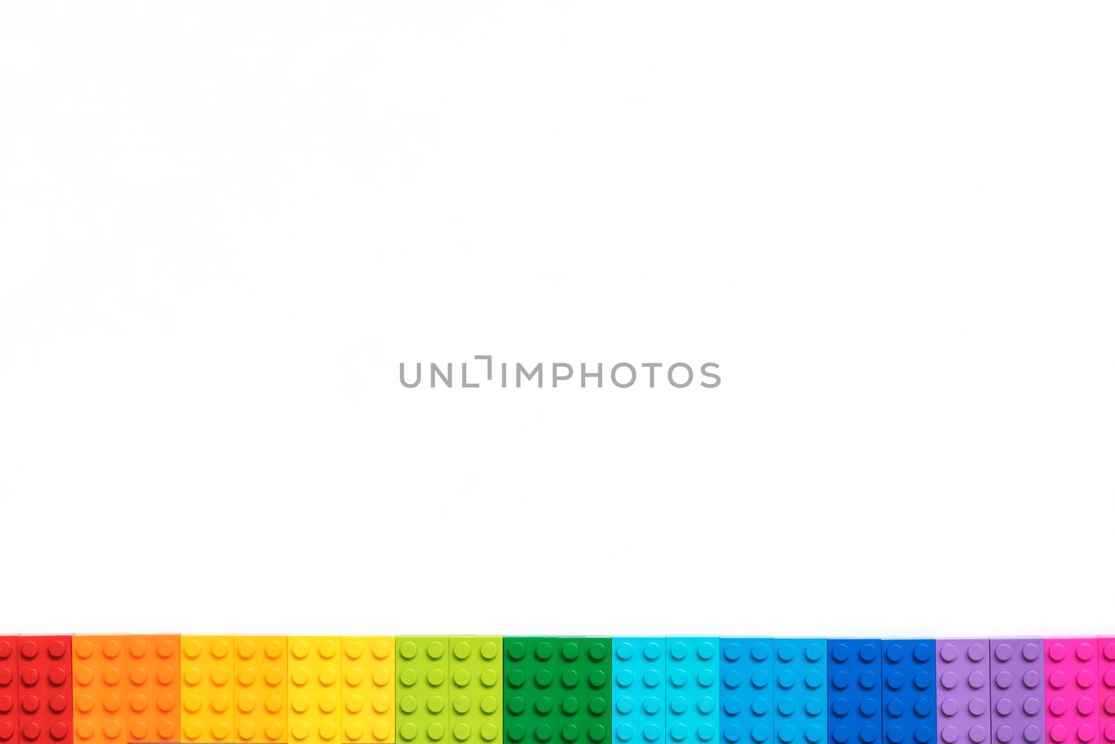 Multicolor Plastick constructor bricks on white background. Popular toys. Copyspace