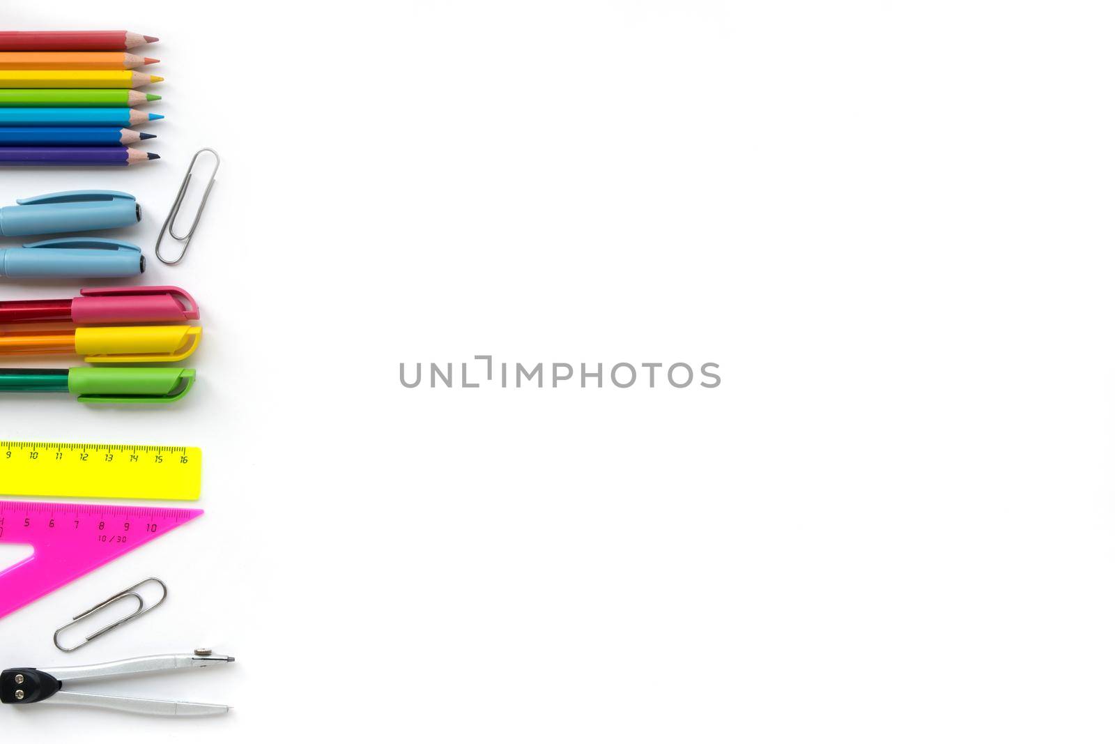 School and Office drawing supplies isolated on white background. Free space for text. Back to school. Top view border of colour pencils, rulers and note