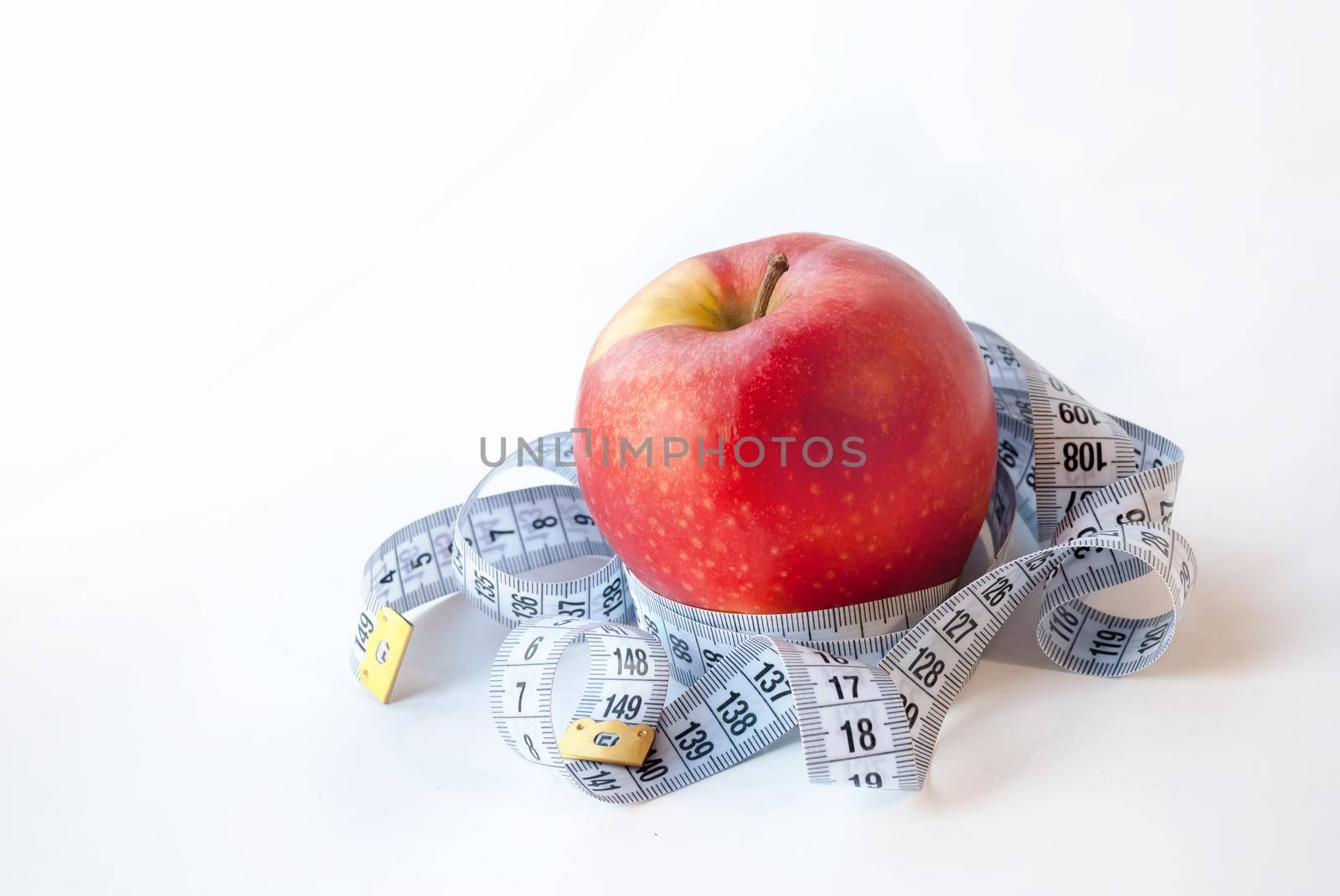 Red Apple and measuring tape on white background. Diet concept. Weight loss