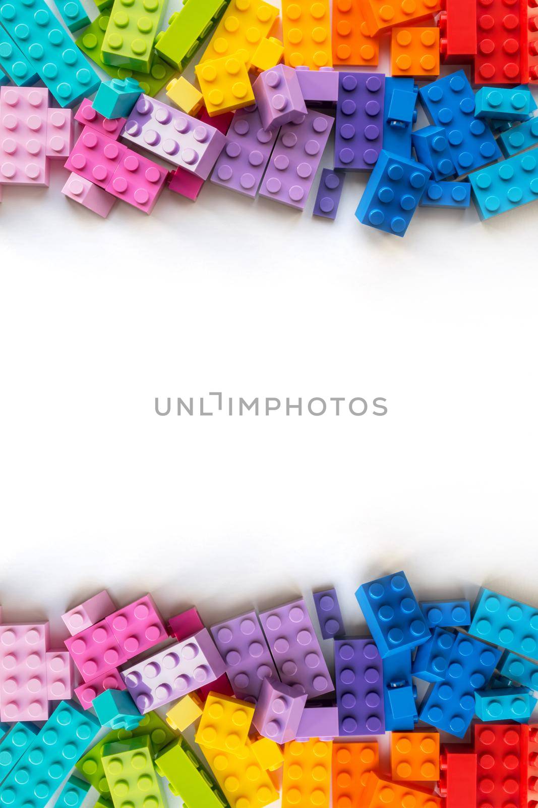 A bunch of Multicolor Plastick constructor bricks on white background. Popular toys. Copyspace