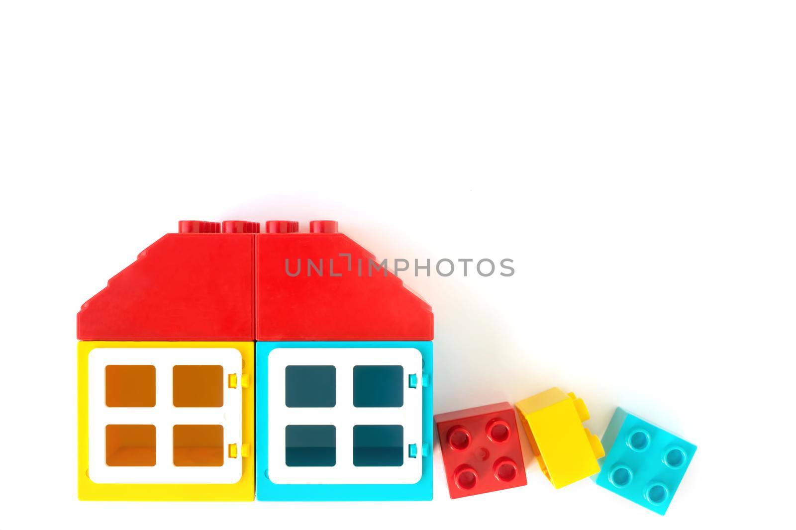 Colorful House made of Small and big plastic constructor bricks on white background. Popular toys.