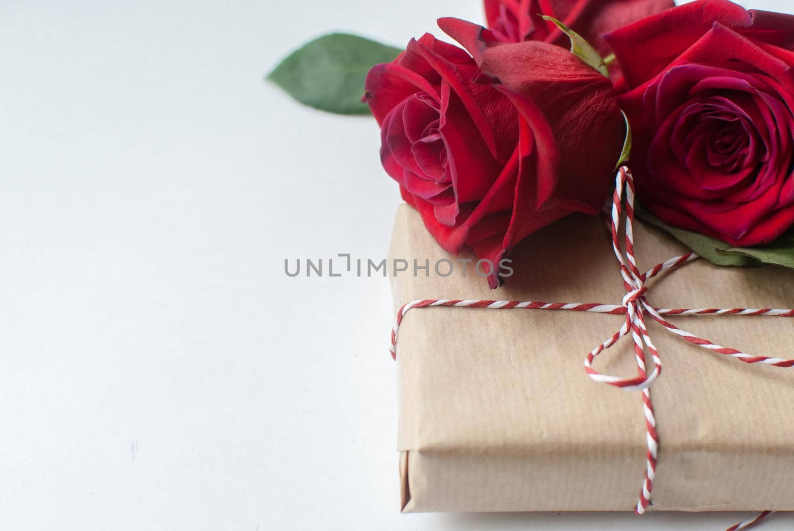 Composition of gift and bouquet of red roses on white background . Happy Valentines Day. Top view. Space for text. Copyspace