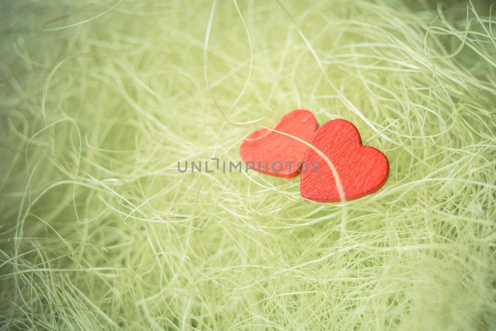 Wooden hearts on a green background sisal