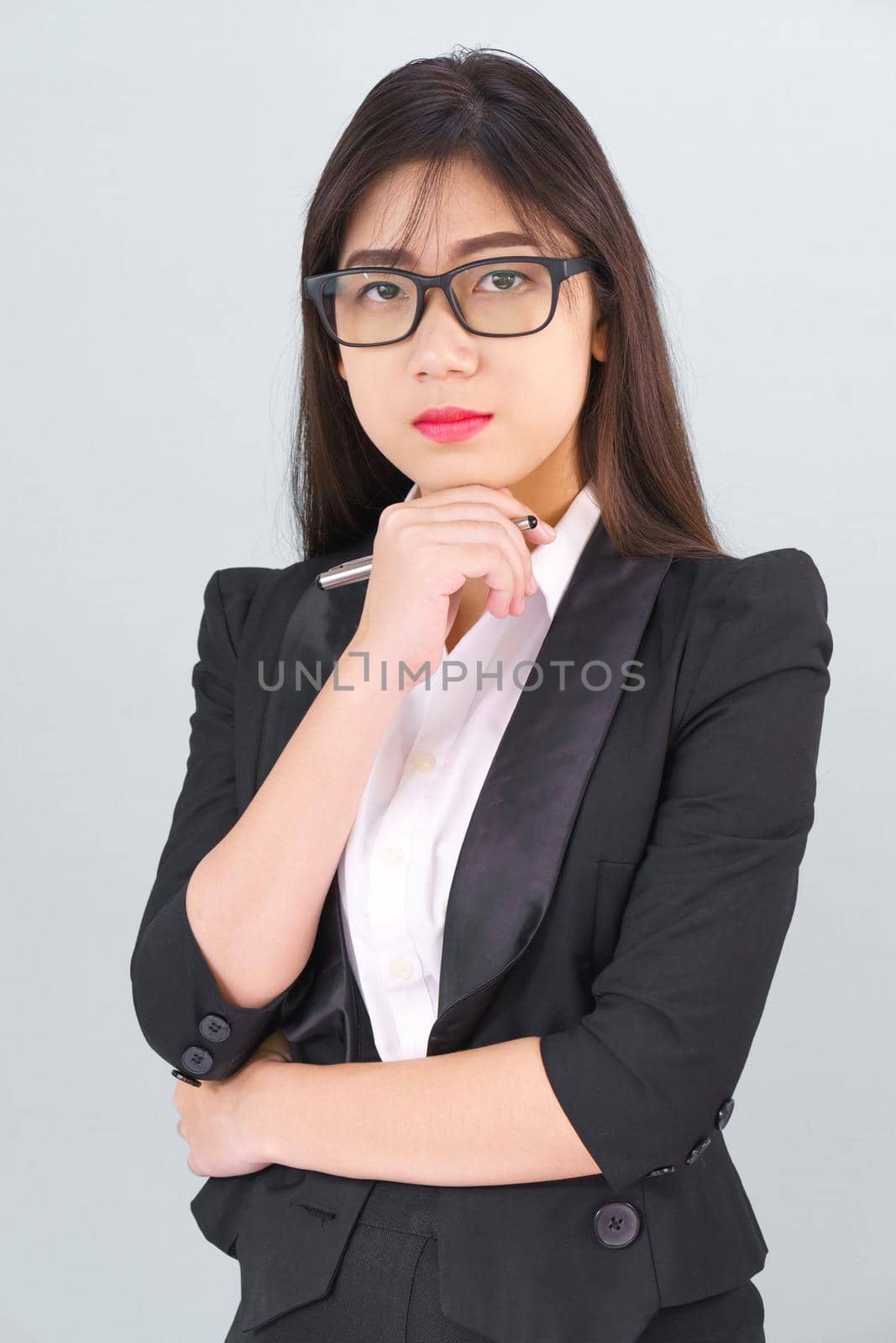 Young asian girl wearing suit with support hand on chin by stoonn