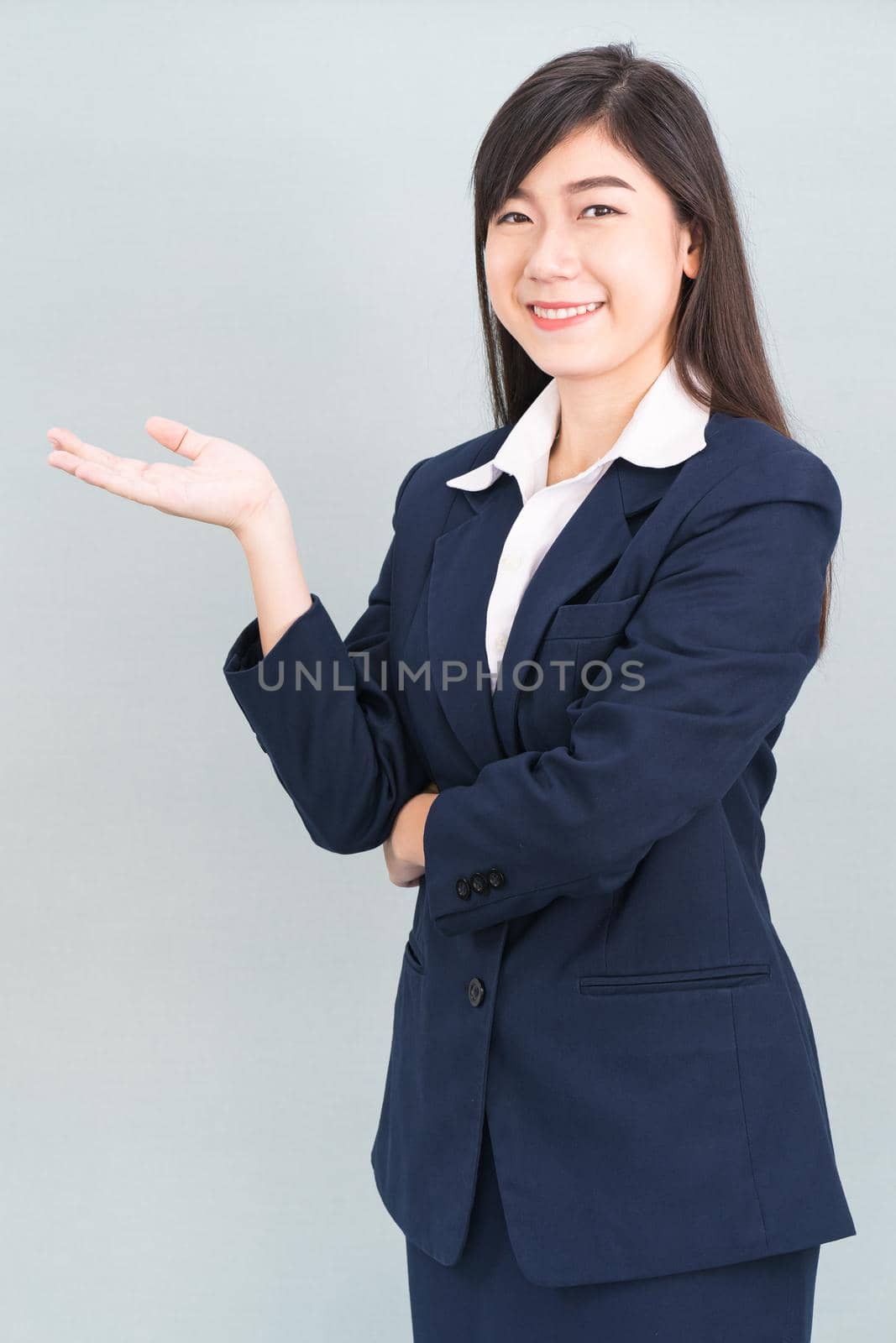 Asian woman in suit open hand palm gestures with empty space isolated on gray background