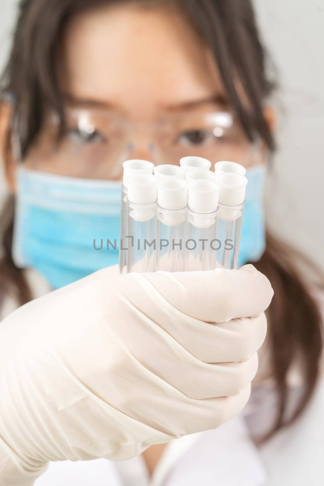 Scientist analyzing holding test tube in laboratory by stoonn