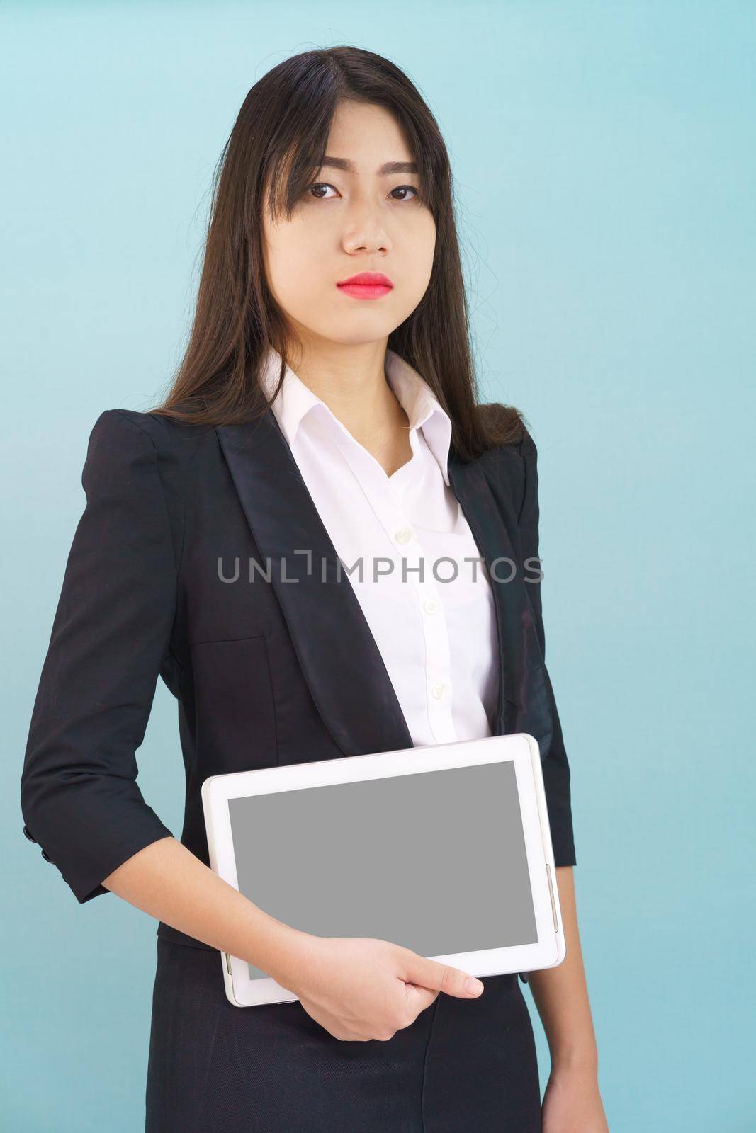 Young women standing in suit holding digital tablet by stoonn