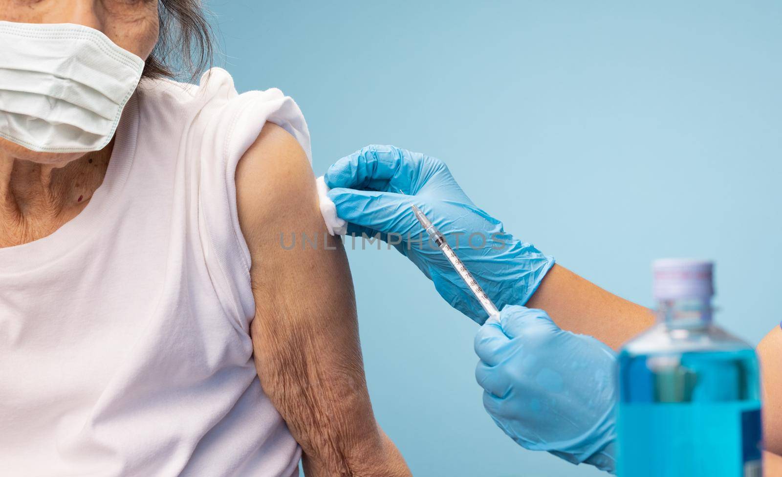 Closeup nurse doing vaccine injection to senior woman.