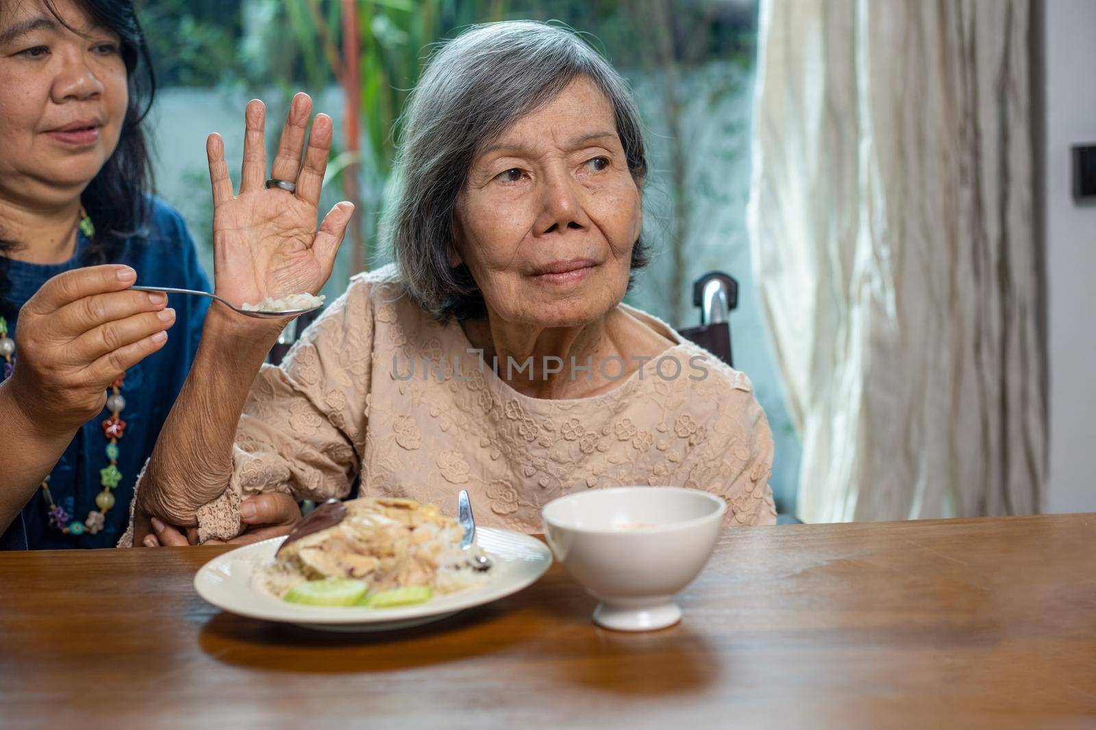 Senior asian woman bored with food.