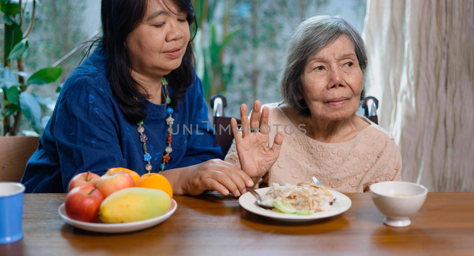 Senior asian woman bored with food.