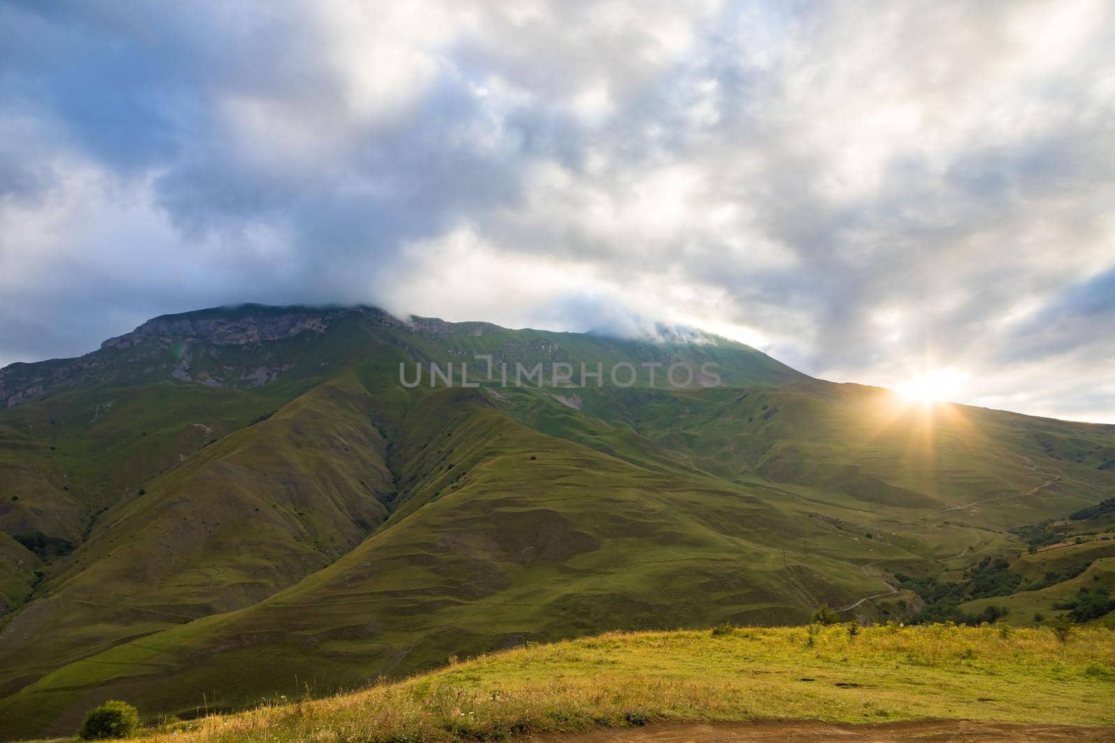 Early morning in the mountains, the first rays of the sun come out over the peaks of the ridge. Magnificent mesmerizing landscape.