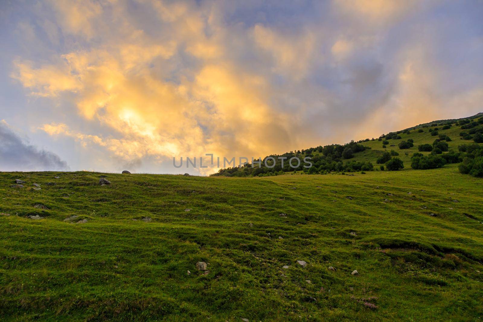 High mountains of the Caucasus with beautiful views. Green vegetation and dense forest above a blue sky. A great fascinating landscape.