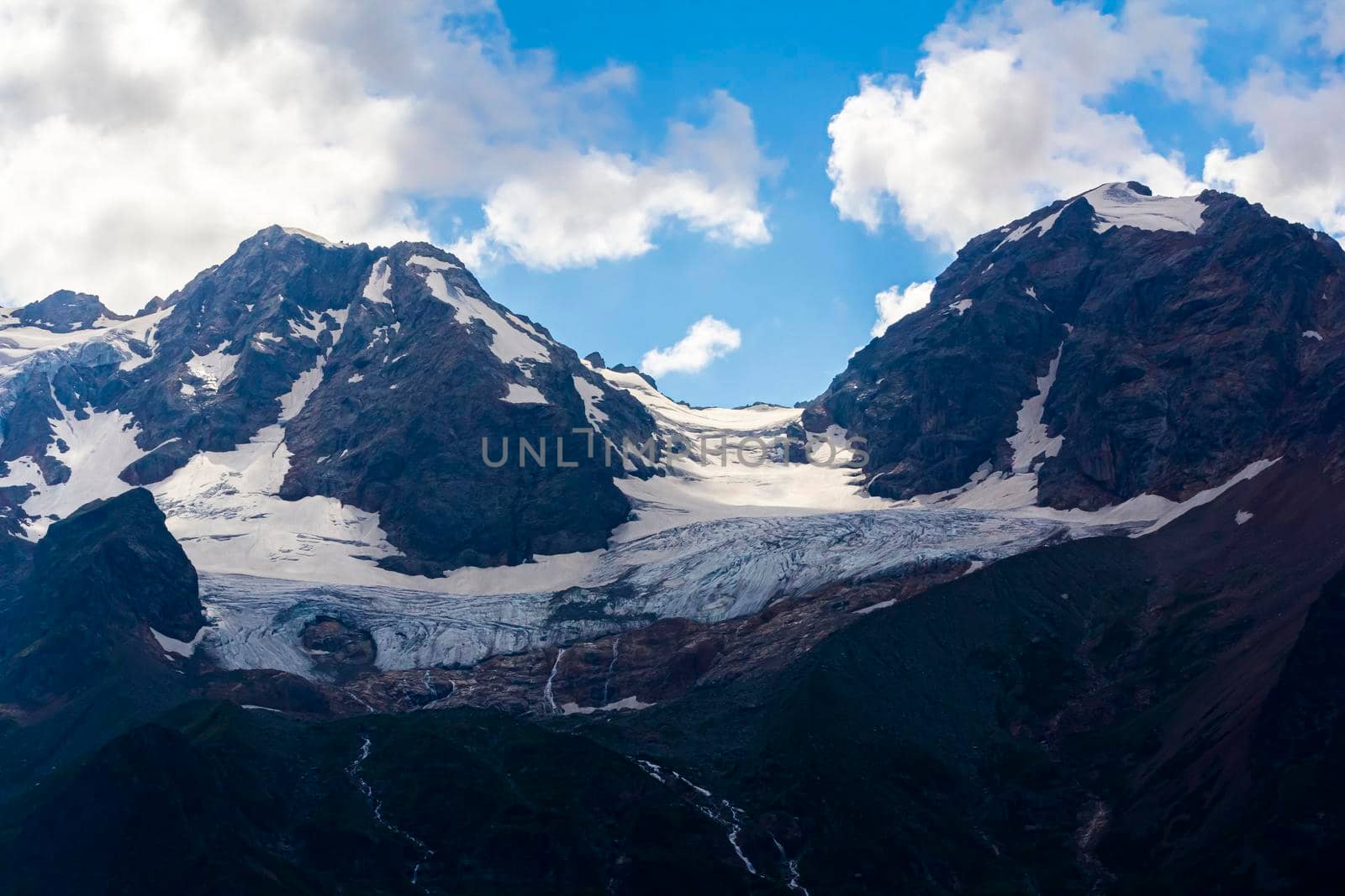 The Caucasus mountains, a glacier on top of the rocks, from the glacier there are three waterfalls. A great fascinating landscape.