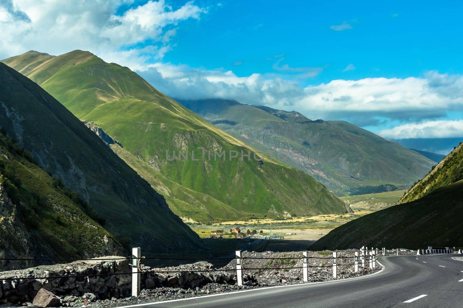 Landscape of the green mountains of the Caucasus thick clouds cover the peaks of the ridge. The outgoing road to the valley.