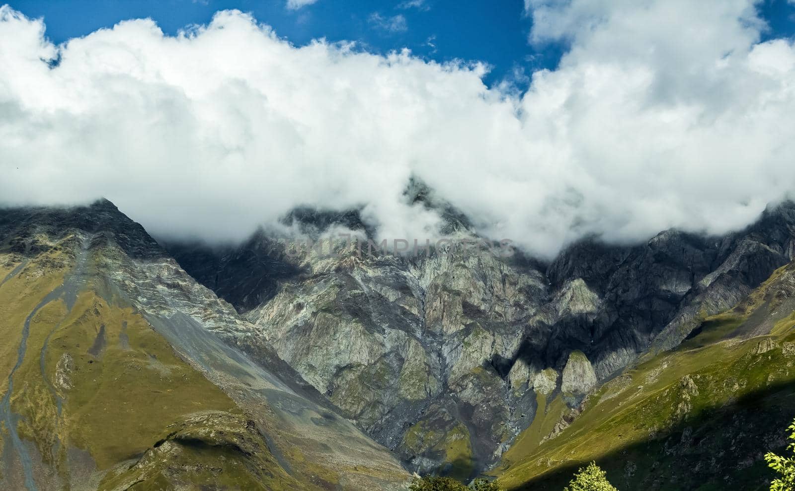 High mountains of the Caucasus with beautiful views. Green vegetation and dense forest above a blue sky. A great fascinating landscape.