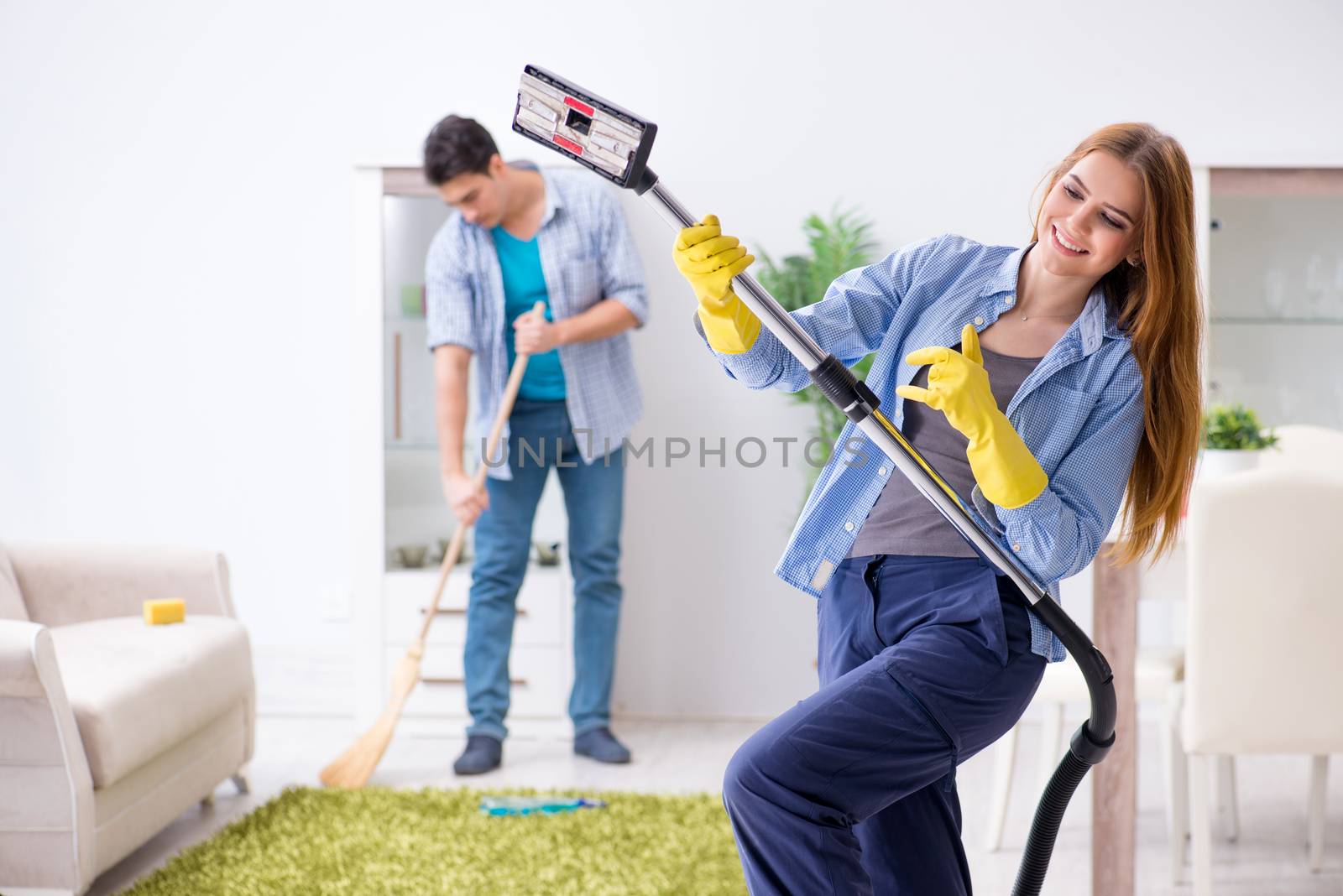Young family cleaning the house by Elnur
