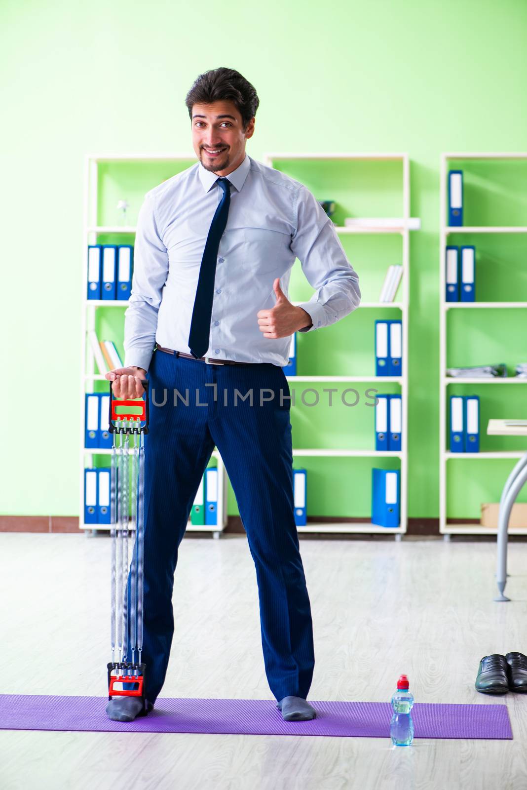 Employee doing exercises during break at work by Elnur
