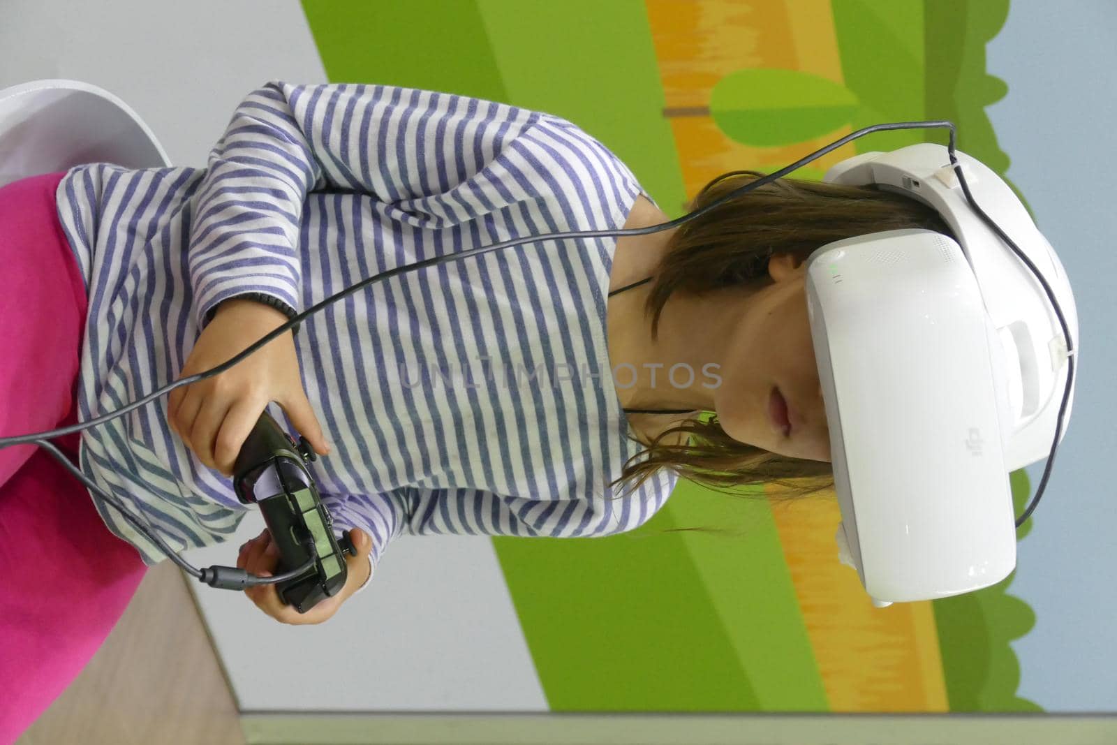 Child girl wearing virtual reality headset in a techno fair
