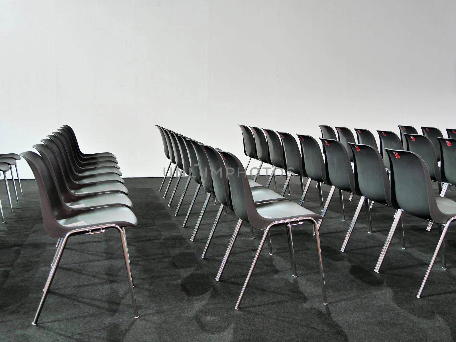 Empty black chairs rows in conference room on white background by lemar
