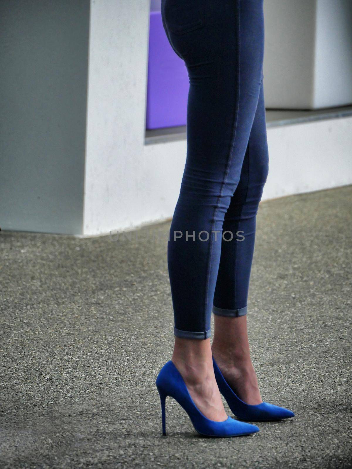 Woman wearing tight jeans and blue high heels shoes close up view
