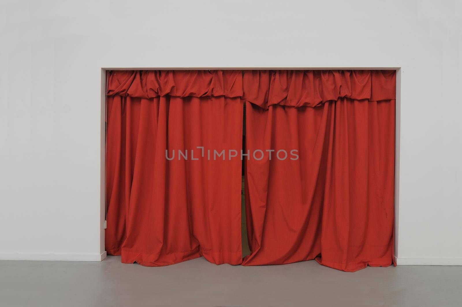 Red curtain closed on white wall