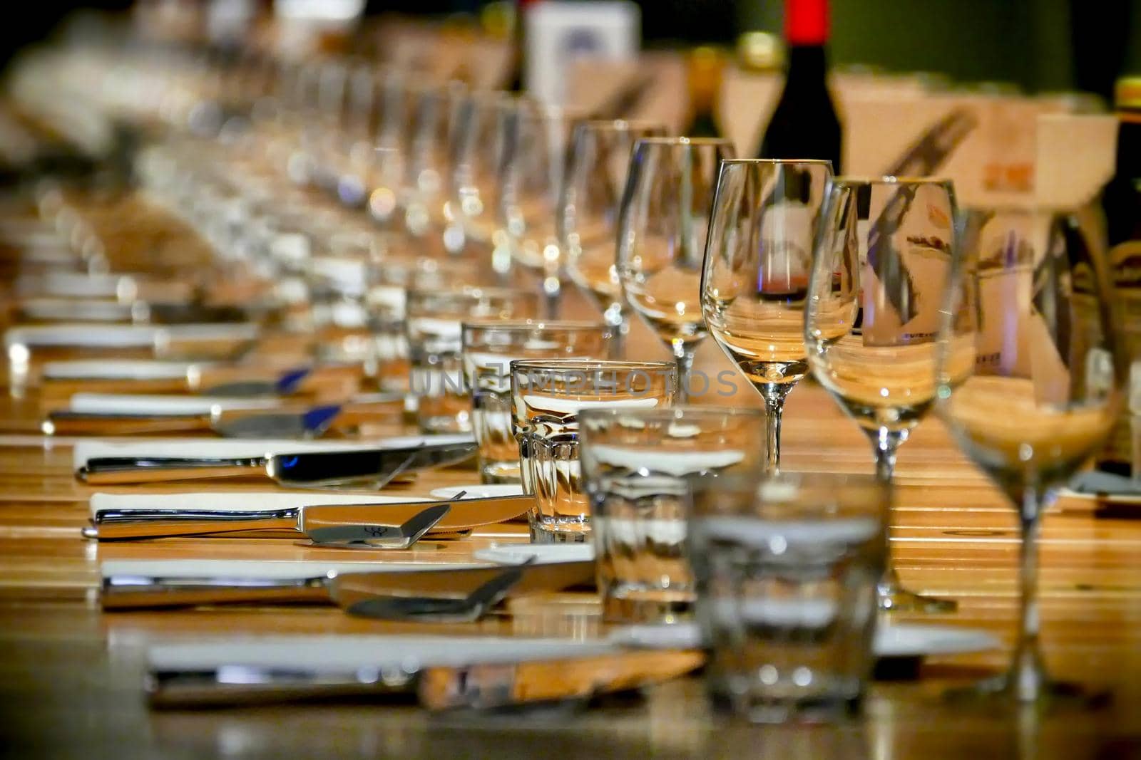 Long row restaurant table setting perspective view selective focus by lemar