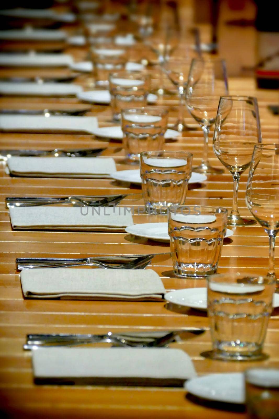 Long row restaurant table setting perspective view selective focus