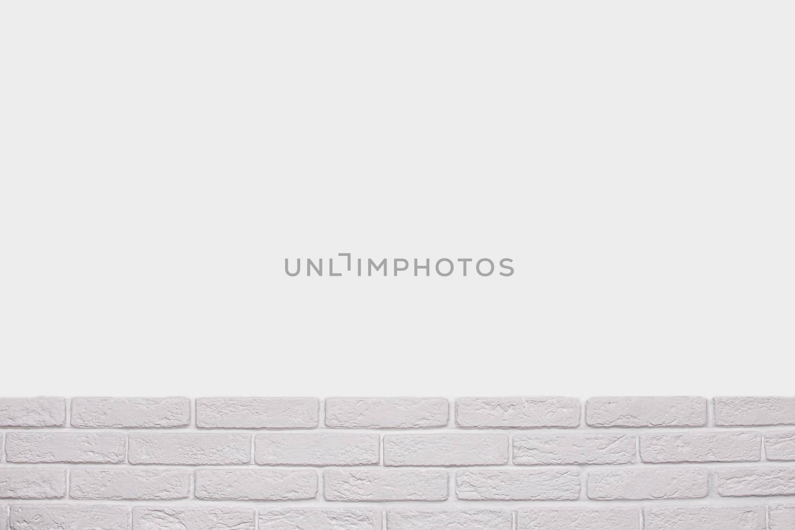 the white background of the wall. below are several rows of bricks with copy space. by ja-aljona