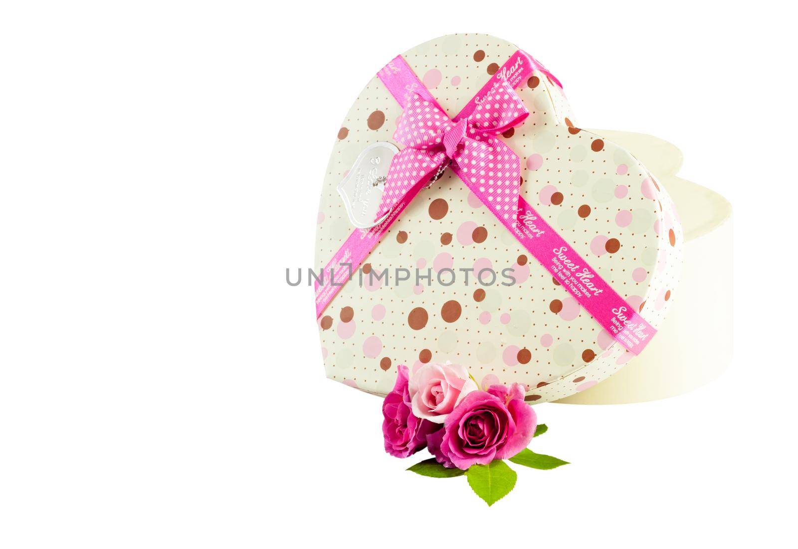 Beautiful beige st.Valentine's Gift box in shape of heart with roses tied with pink tape. Isolated on white background with space for free text.