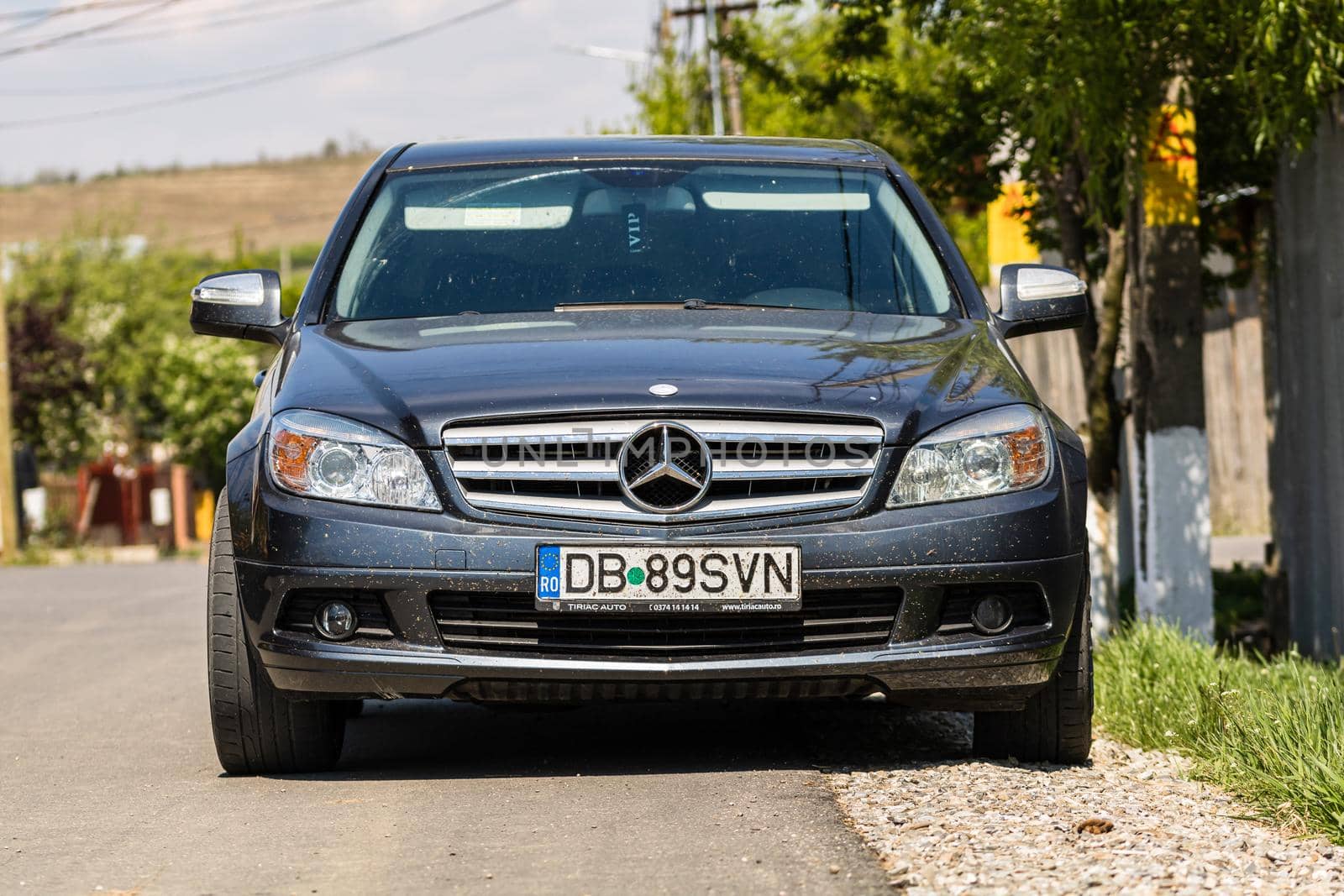 Dirty Mercedes car parked along the street in Razvad, Romania, 2020 by vladispas