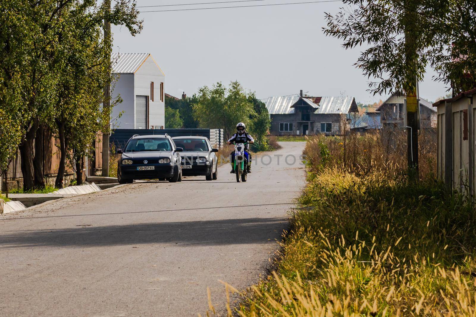 Rider on his enduro motorbike on a village road near Targoviste, Romania, 2020
