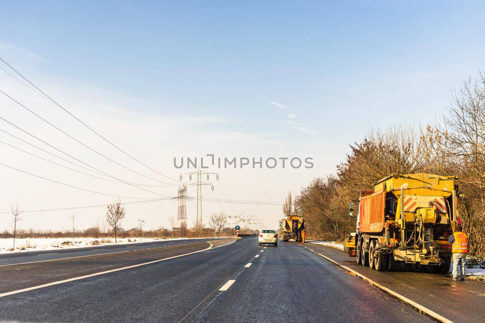 Winter season, view of cars and snowy street through windshield while driving in Bucharest, Romania, 2021.   by vladispas