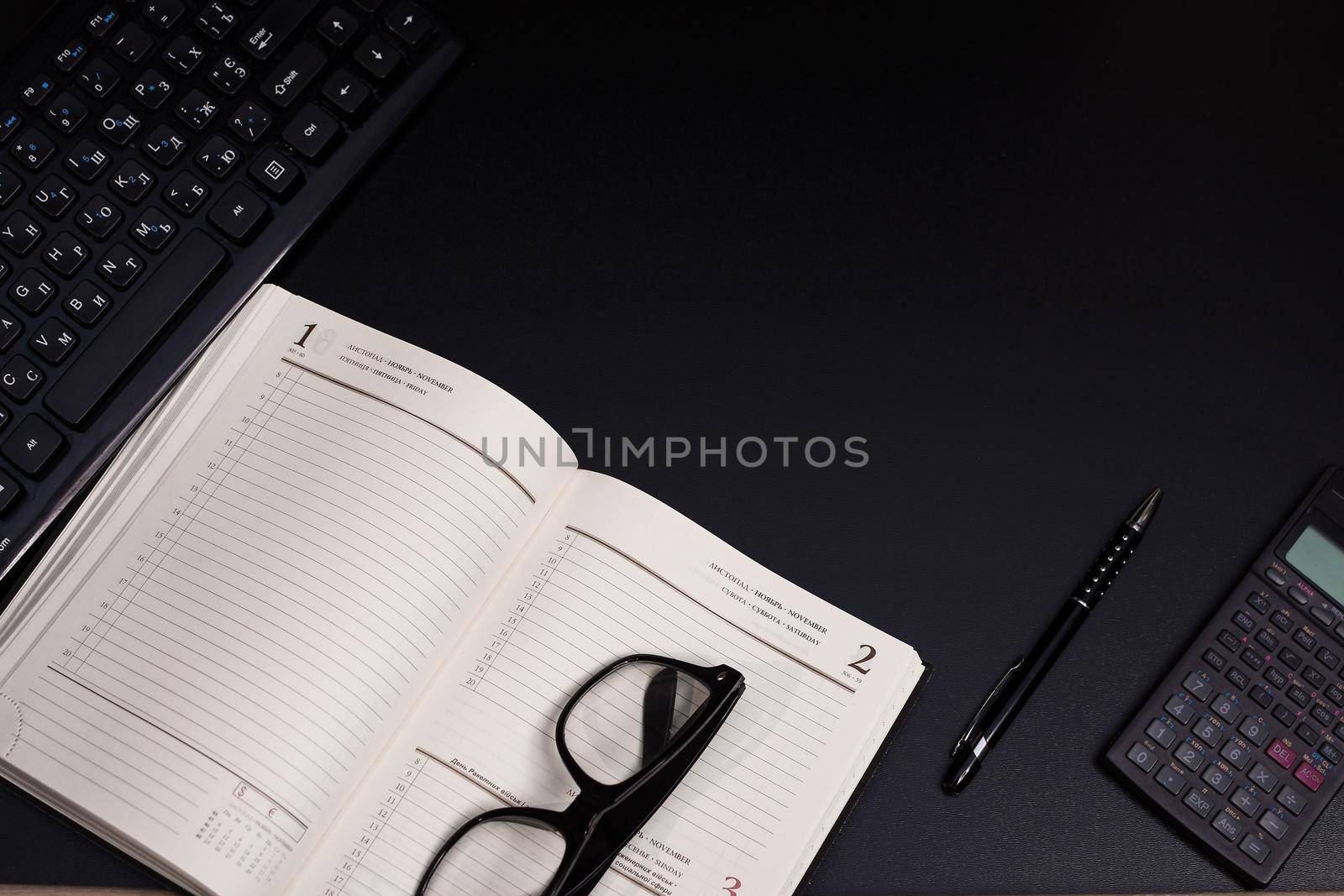 Black desk office with keyboard, calculator and other work supplies. Top view with copy space for input the text. Designer workspace on desk table essential elements on flat lay. Place for an inscription. . High quality photo