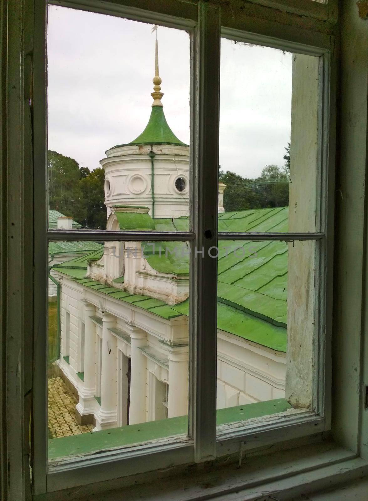 Abandoned mansion. View through the window to the tower. Can be used as demolition, antiquity, vintage concept. by mtx