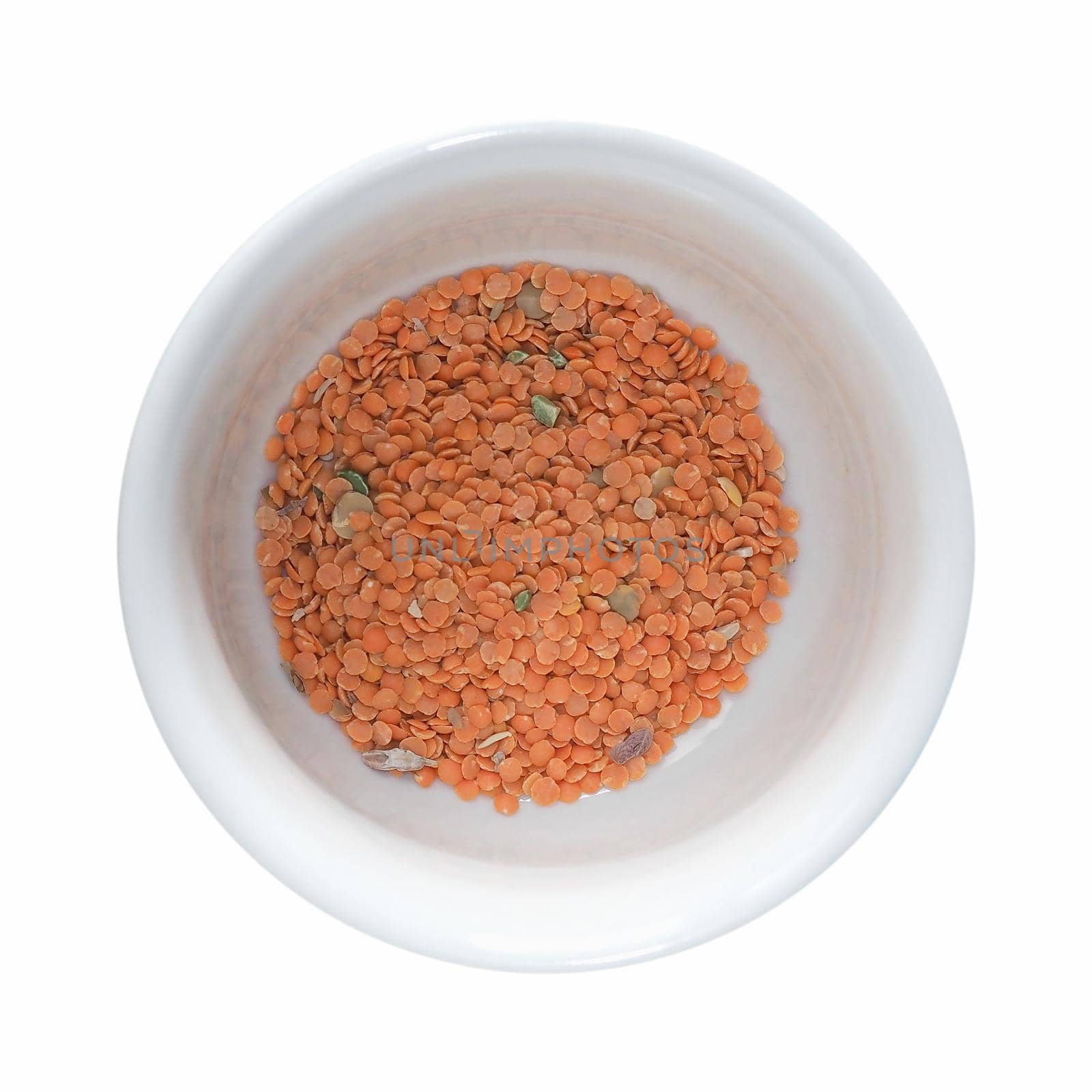 red lentils in a bow on a table isolated over white background