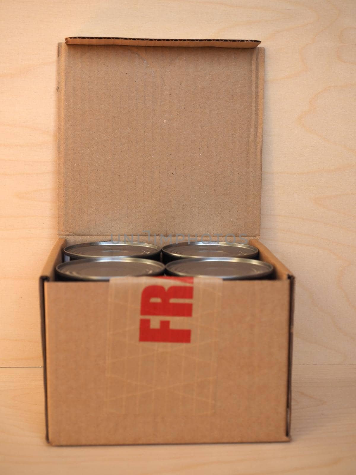 Fragile cardboard box with tin cans by claudiodivizia