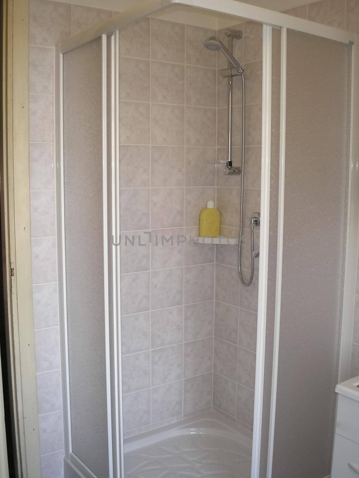 View of residential bathroom shower and cabinets