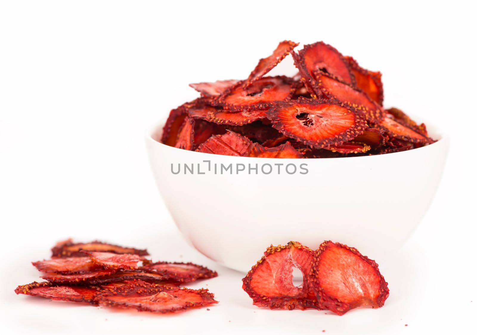 dry strawberry in a white plate, strawberry fruit chips isolated on white background by aprilphoto