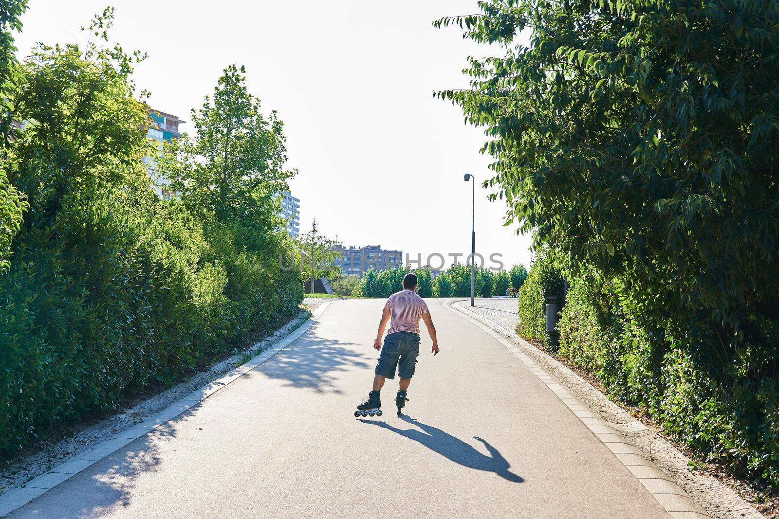 Man skating with cap between trees