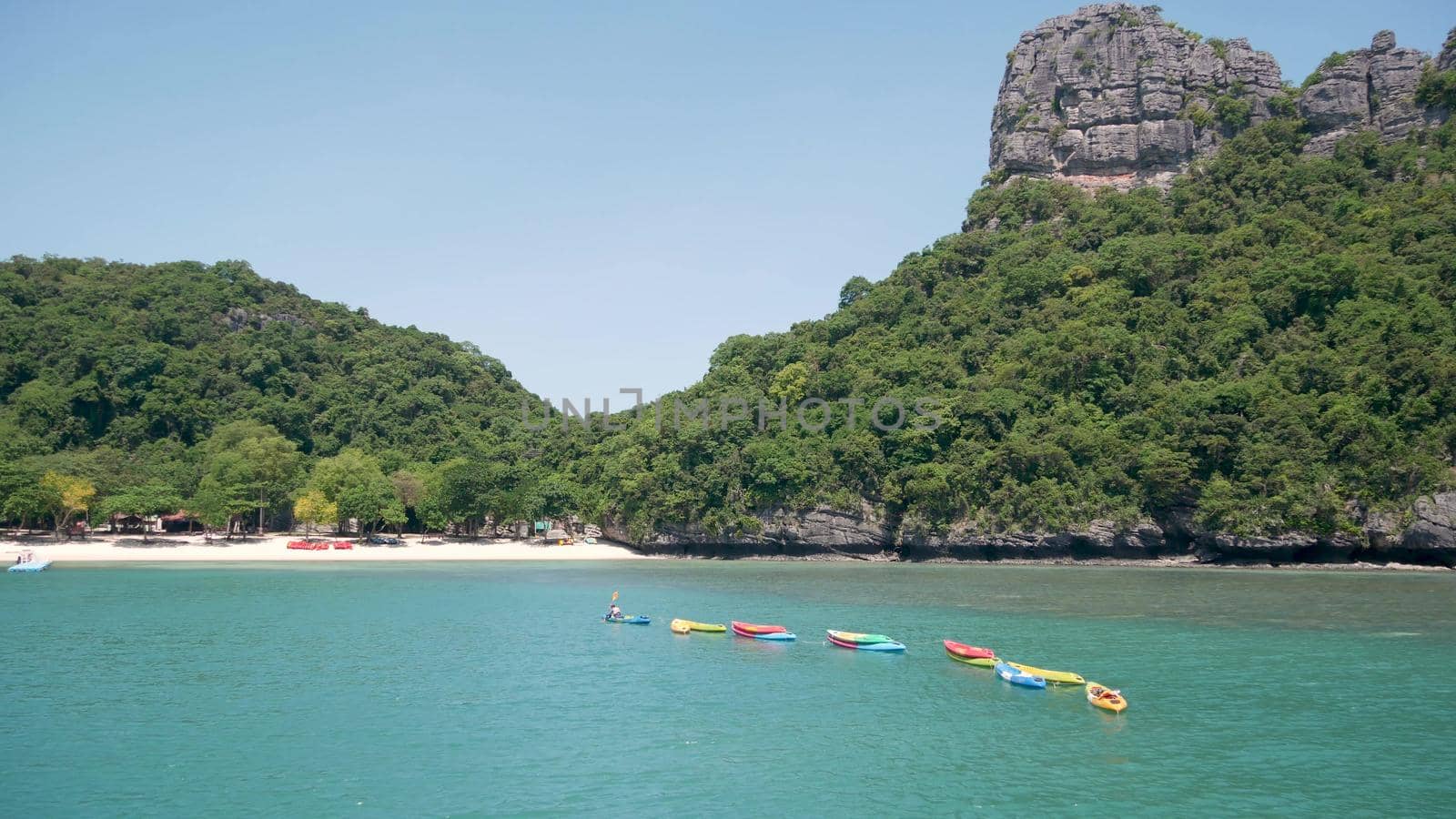 Islands in ocean at Ang Thong National Marine Park near touristic Samui paradise tropical resort. Idyllic turquoise sea natural background with copy space. Kayaks and colorfull sports canoes by DogoraSun